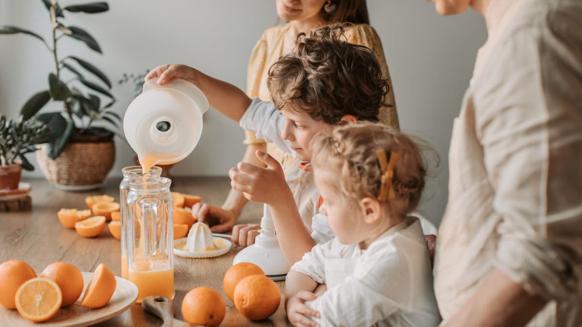 A family bonding over making fresh orange juice at home, enjoying quality time together.